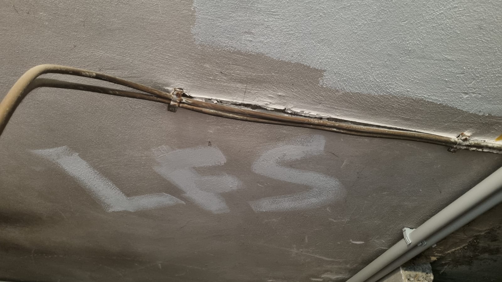 LFS geschrieben an eine Kellerdecke, die gestrichen wird.